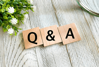 木のタイルで並べられたQ&Aの文字と観葉植物